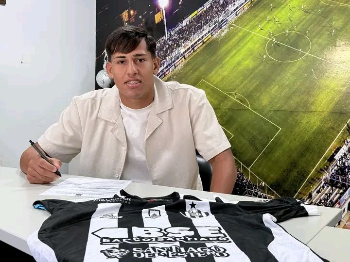 Fotografia del nuevo jugador de Güemes Bautista Gerez sentado en un escritorio, con un bolígrafo en la mano, firmando los documentos oficiales de renovación de su contrato para la temporada 2025 con su antiguo club.